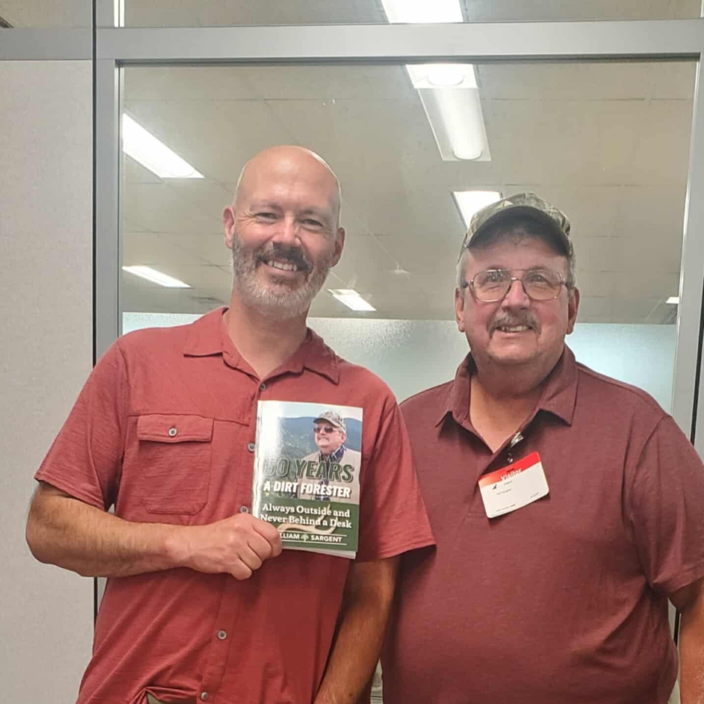 A reader holding a copy of the book beside the author